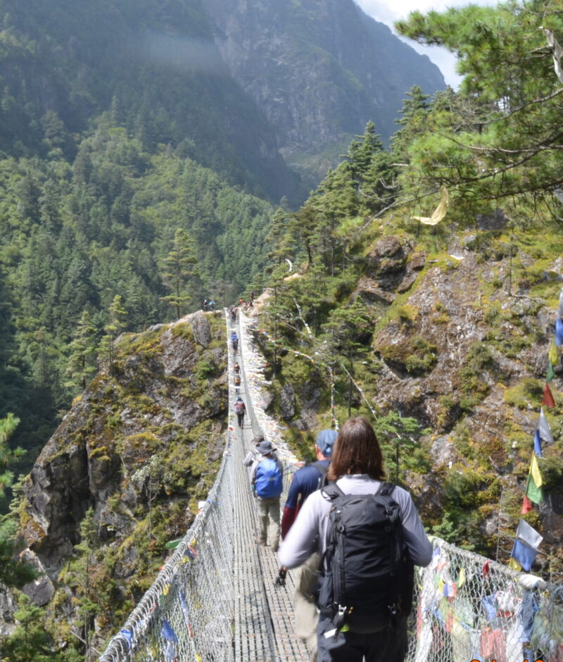 Trekkers crossing suspension bridge en-route Namche